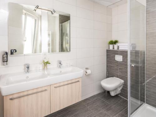 a bathroom with a sink and a toilet and a shower at Hotel & Restaurant Möwchen in Norden