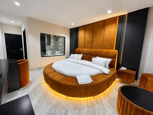 a bedroom with a large bed with a wooden headboard at One One B Luxury Hotel in Asaba