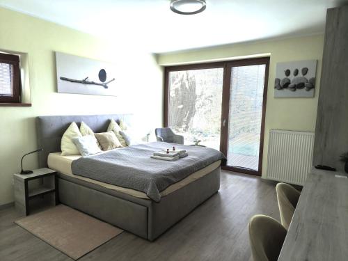 a bedroom with a bed and a large window at Apartmány Kvetná in Rajecké Teplice