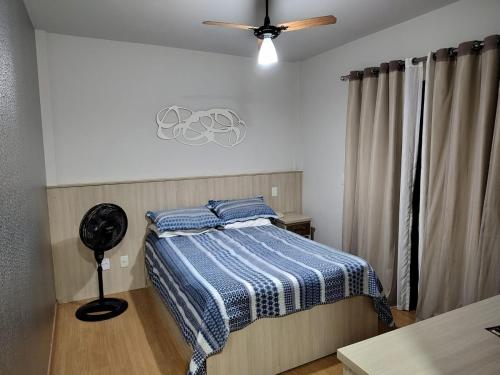 a bedroom with a bed and a ceiling fan at Serra Negra Piemonte Flat Paz e Lazer Num Só Lugar in Serra Negra