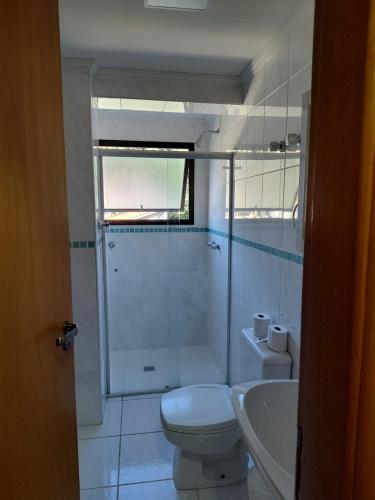 a bathroom with a toilet and a shower and a sink at Serra Negra Piemonte Flat Paz e Lazer Num Só Lugar in Serra Negra