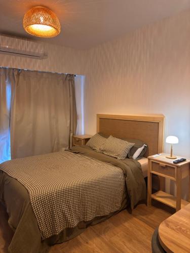 a bedroom with a bed and a table with a lamp at Hermoso departamento Saavedra 4741 in Buenos Aires