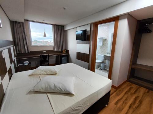 a bedroom with two beds and a window at Hotel Maestro Executive Toledo in Toledo
