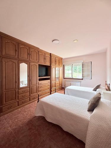 a large bedroom with two beds and wooden cabinets at Casa Romai Portas in Romay
