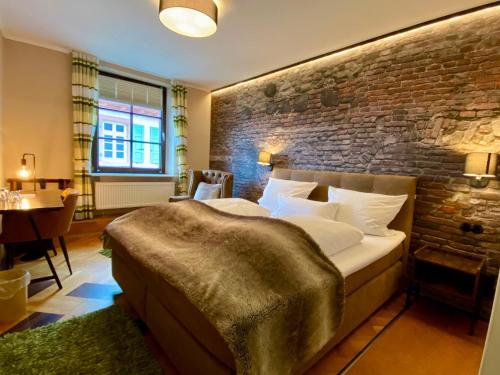 a bedroom with a large bed and a brick wall at Zum Burggraf in Neuleiningen