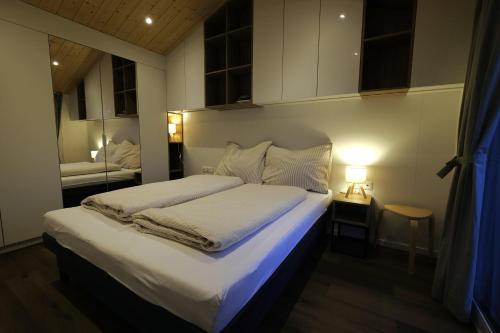 a bedroom with a large bed with white sheets at Häuschen am Traunig in Hermagor