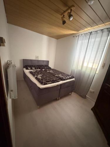 a bed in a small room with a window at Ferienwohnung Freudenberg in Freudenberg am Main