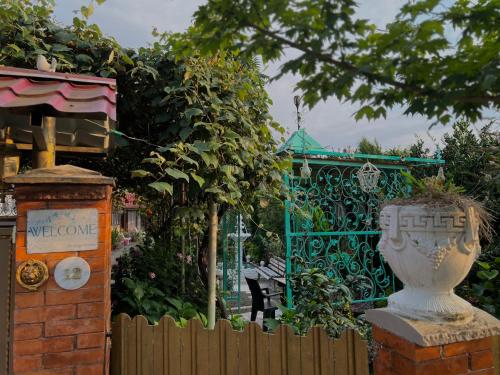 a garden with a fence and a bench and a gate at SeGi Garden Home in Khobi