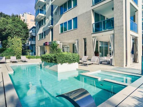 una piscina di fronte a un edificio di Mercure Hotel Rimini Artis a Rimini