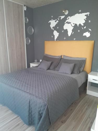 a bedroom with a bed with a world map on the wall at DFC Salta Estudio 2p in Salta