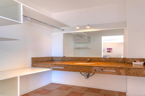 a bathroom with a sink and a mirror at Express Floripa Residence in Florianópolis