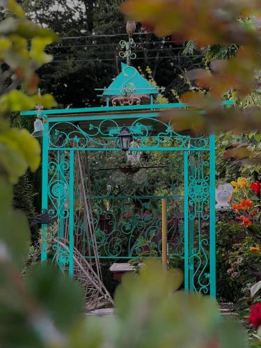 a blue gate in a garden with flowers at SeGi Garden Home in Khobi