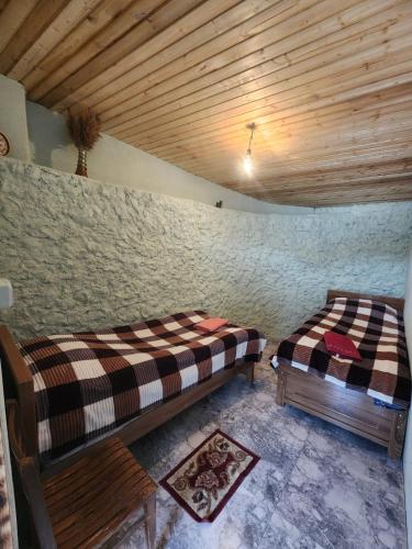 two beds in a room with a wooden ceiling at guest house "BETQIL" adishi in Adishi