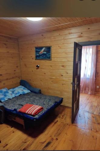 a bedroom with a bed in a room with wooden walls at Akacia in Svityazʼ