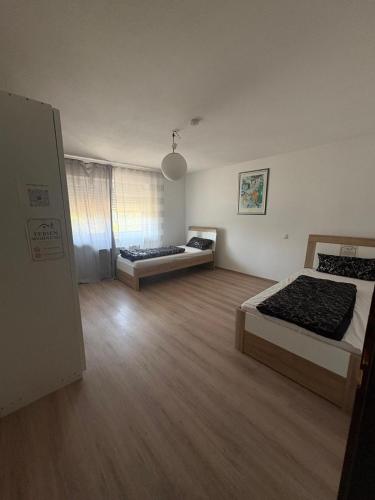 two beds in a large room with wooden floors at Ferienwohnung Freudenberg in Freudenberg am Main