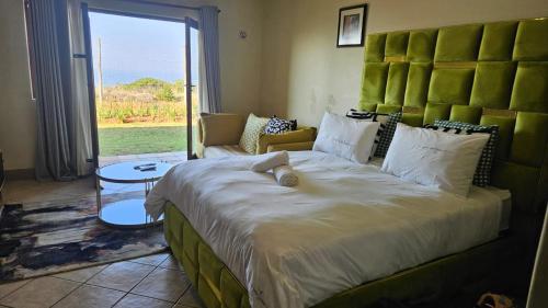 a bedroom with a large bed with a large headboard at Ocean View Villas F3 in Port Edward
