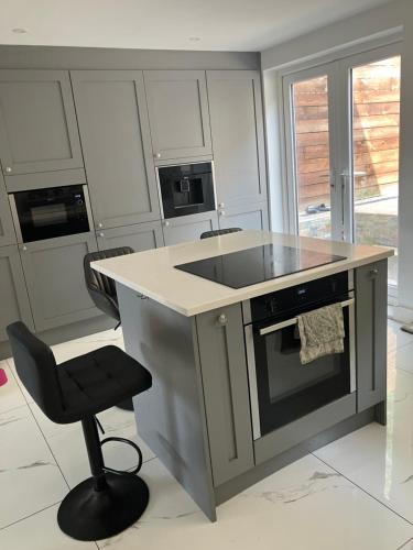 a kitchen with an island with a sink and a chair at Ilsyn Grove in Brislington