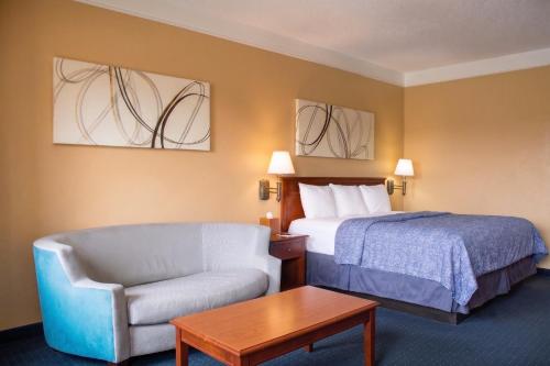 a hotel room with a bed and a chair at Hatteras Island Inn in Buxton