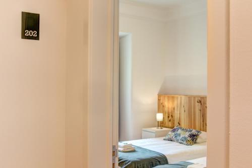a hotel room with a bed and a mirror at Home Out Rooms & Apartments in Lisbon