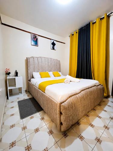 a bedroom with a large bed with yellow curtains at Nyeri 1 Bedroom BnB in Nyeri