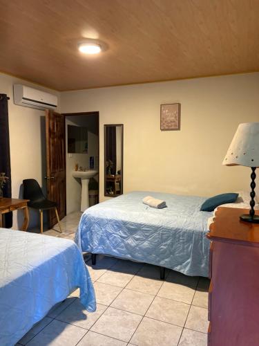 a bedroom with two beds and a table with a lamp at Beach House EL Cocalito in La Libertad