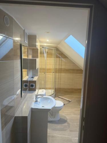 a bathroom with a white toilet and a sink at Cosy accommodation in Dańce