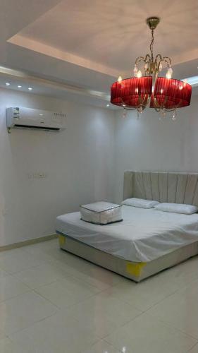 a bedroom with a bed and a chandelier at فلة وشاليه ابحر الشمالية in Jeddah
