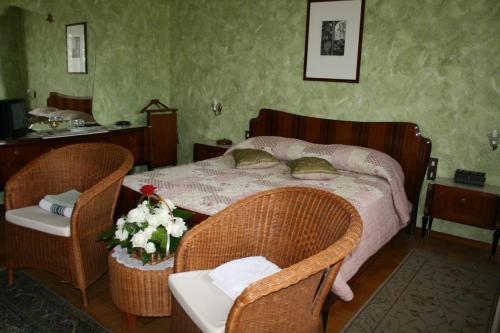 1 dormitorio con 1 cama con 2 sillas y 1 mesa en B&B Il Glicine, en bedizzol