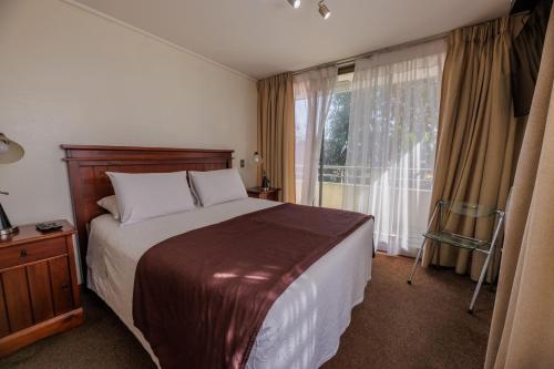 a bedroom with a bed and a large window at SINGLE RENT'APARTMENT in Concepción