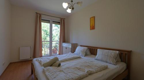 a bedroom with a large bed with a window at Villa Palazzo Apartments in Siófok