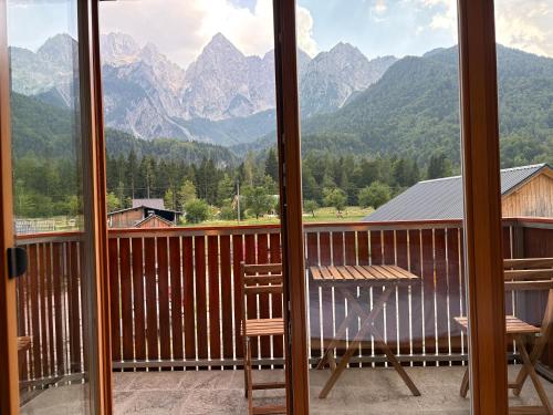 a balcony with a table and chairs and mountains at Apartment Barbara with sauna in Gozd Martuljek