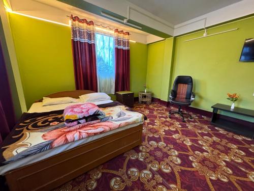 a bedroom with a bed and a chair in a room at The Mirik Address in Mirik