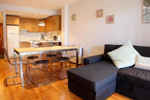 a living room with a couch and a table and a kitchen at Apartamento Alfa con parking y wifi by SURYNIEVE in Sierra Nevada