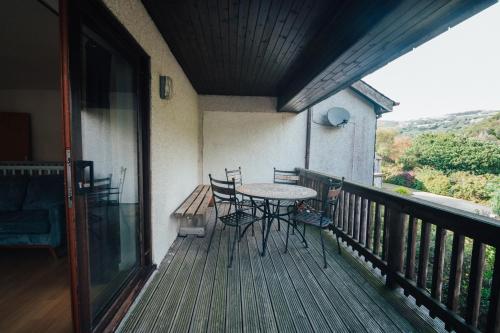 a porch with a table and chairs on a balcony at The Welsh Hideaway in Llanberis