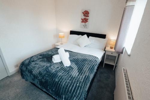 a bedroom with a bed with two towels on it at Dinorben Retreat in Amlwch