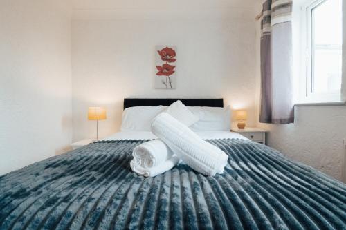 a bedroom with a large bed with a blue blanket at Dinorben Retreat in Amlwch