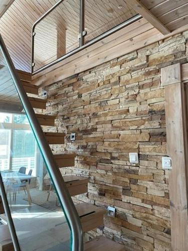 a stone wall in a room with a staircase at Villa Loiste Himos Chalet with Hot Tub in Jämsä