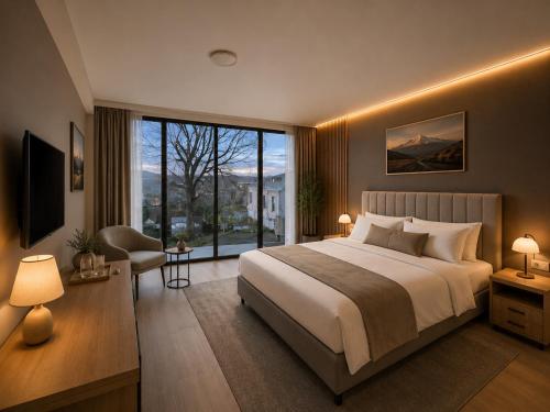 a bedroom with a large bed and a large window at Garslyan Boutique Hotel in Ninotsminda