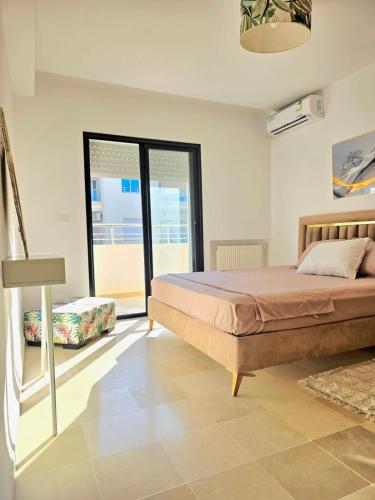 a bedroom with a bed and a large window at S2 vip nouvelle soukra in Sukrah