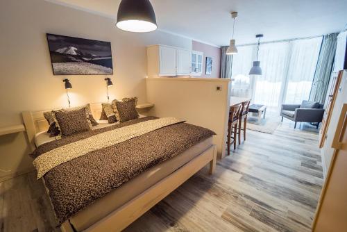 a bedroom with a bed and a dining room at Pension Linda in Harrachov