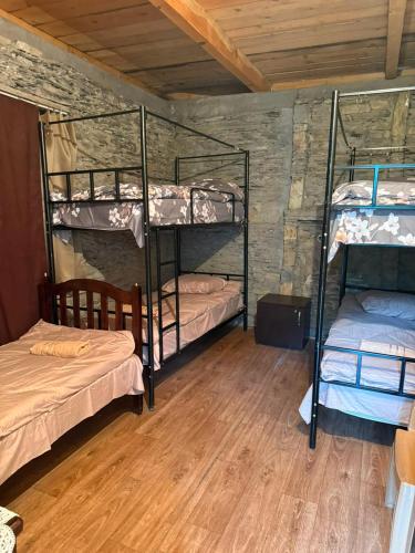 a room with three bunk beds and a wooden floor at Guesthouse Mountain House in Khalde