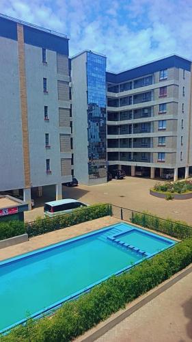 an empty swimming pool in front of a building at Amaziah apartment Mimyhomes in Nairobi