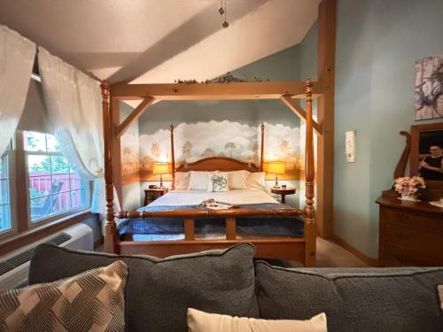 a bedroom with a canopy bed with a couch at The Barn Inn Bed and Breakfast in Millersburg