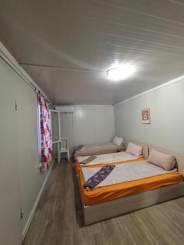 two beds in a small room with a window at Blue and white in Pleven