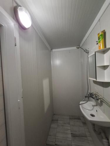 a bathroom with a sink and a toilet and a light at Blue and white in Pleven