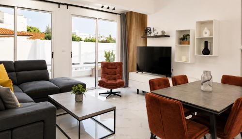 a living room with a couch and a table at Nerina Townhouse By Staycom in Paphos