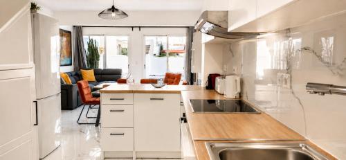a kitchen with white cabinets and a stainless steel sink at Nerina Townhouse By Staycom in Paphos