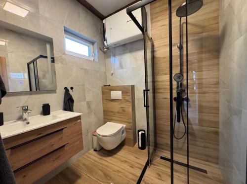 a bathroom with a shower and a toilet and a sink at Apartman Bor in Kiseljak