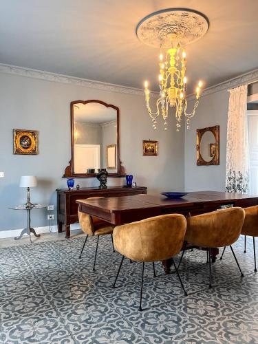 a dining room with a table and chairs and a chandelier at B&B Dàmur in Piazza Armerina
