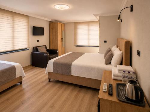 a hotel room with two beds and a desk at Iotape Hotel Antalya in Işıklı